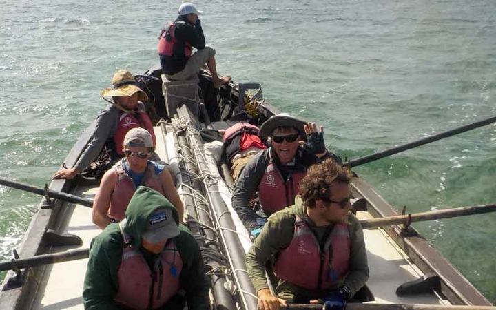 a small group of people navigate a sailboat on an outward bound expedition in florida